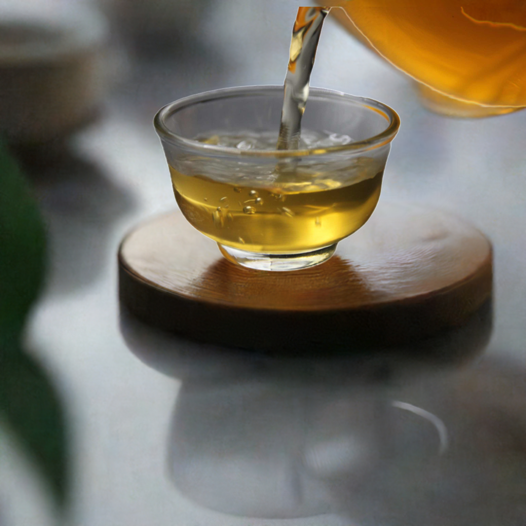 2014 Auspicious Cake Ancient Tree Raw Pu-erh Tea pouring into a glass cup