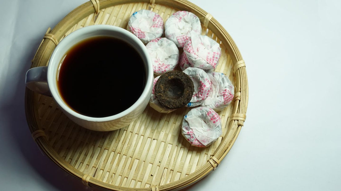 Pu-erh tea in cup alongside with Pu-erh cakes