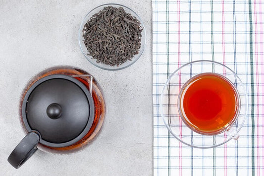 Pu-erh tea in pot and cup with leaves