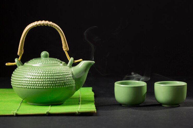 Green tea in pot and cups