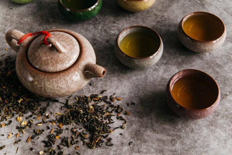 Tea Pot and cups with Pu-erh tea and leaves