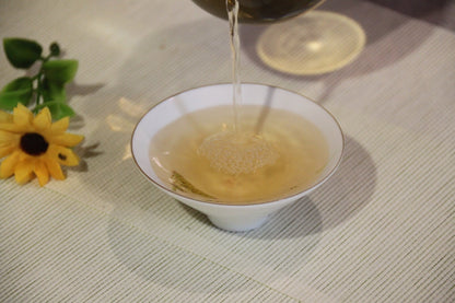 2012 Auspicious Cake Ancient Tree Raw Pu-erh Tea in a Chinese Cup